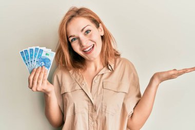 Kafkasyalı genç bir kadın 50 Polonyalı zloti parasıyla başarıyı mutlu bir gülümsemeyle ve kazanan ifadeyle kutluyor. 