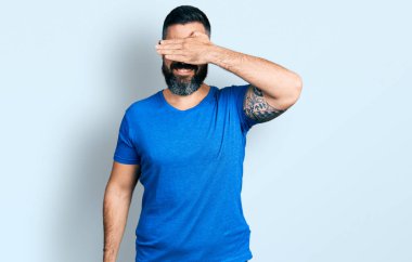 Sakallı, sıradan tişörtlü, gözlüklü, gülümseyen ve gülen İspanyol bir adam. kör kavram. 