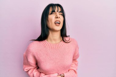 Kâküllü genç esmer kadın, mide bulantısı, acı verici bir hastalık yüzünden normal bir kazak giyiyor. Ağrı kavramı. 