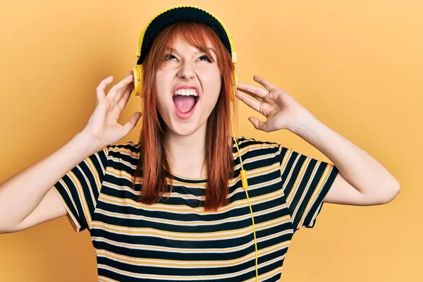 Redhead Young Woman Listening Music Using Headphones Angry Mad Screaming — Stock Photo, Image