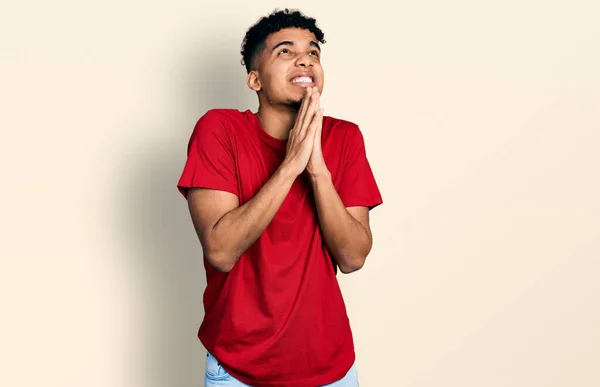 Joven Hombre Afroamericano Vistiendo Casual Camiseta Roja Mendigando Rezando Con — Foto de Stock