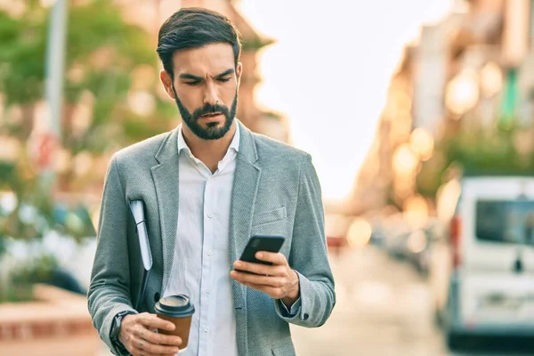 Jonge Spaanse Zakenman Met Serieuze Expressie Met Smartphone Het Drinken — Stockfoto