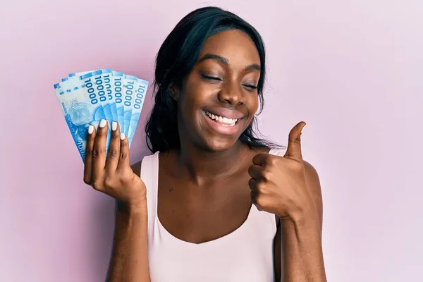Joven Mujer Afroamericana Sosteniendo 10000 Pesos Chilenos Sonriendo Feliz Positivo — Foto de Stock