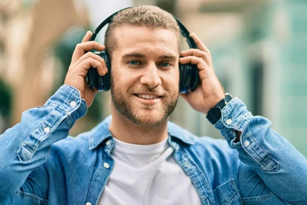 若い白人男性笑顔幸せな使用ヘッドフォンで市内 — ストック写真