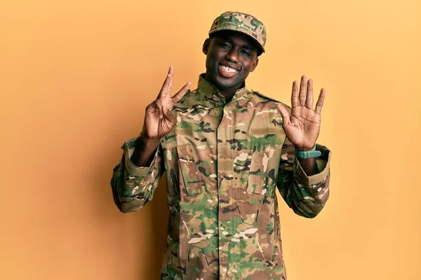 自信を持って幸せな笑みを浮かべている間 若いアフリカ系アメリカ人の男性は 軍の制服を着て指の数8で示すと指摘 — ストック写真