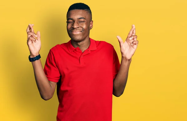 Νεαρός Αφροαμερικάνος Κόκκινο Πουκάμισο Σταυρώνει Δάχτυλο Χαμογελώντας Ελπίδα Και Μάτια — Φωτογραφία Αρχείου