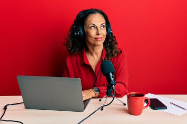 Güzel orta yaşlı kadın radyo stüdyosunda çalışıyor. Gülümsüyor, yan tarafa bakıyor ve düşünüyor.. 
