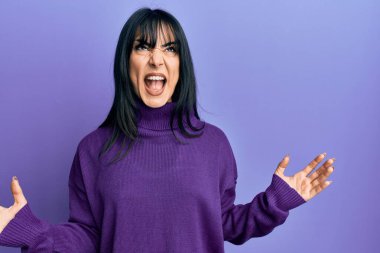 Kâküllü, balıkçı yaka kazak giyen genç esmer kadın deli gibi bağırıyor ve agresif bir ifade ve kollarla bağırıyor. hüsran kavramı. 
