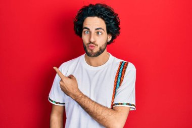 Yakışıklı ispanyol adam parmaklarıyla yan tarafı işaret ederek balık suratlı ve şaşı gözlü, çılgın ve komik.. 