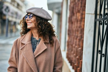 Orta yaşlı İspanyol kadın gülümseyerek şehirde mutlu mesut dikiliyor..