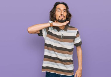 Gündelik kıyafetler giyen, boğazını bıçak niyetine kesen, saldırganlığı şiddetle tehdit eden genç İspanyol bir adam. 