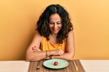 Yüzünde mutlu ve havalı bir gülümsemeyle diyette olan orta yaşlı güzel bir kadın. diş gösterme. 