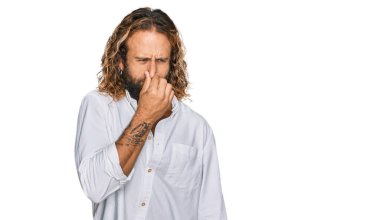 Sakallı, uzun saçlı, sıradan kıyafetler giyen, kötü ve iğrenç bir koku alan, nefesini burnunda tutan yakışıklı bir adam. Kötü kokuyor. 