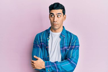 Yakışıklı İspanyol bir adam günlük kıyafetler giyiyor gülümsüyor ve yan tarafa bakıyor ve düşünüyor.. 