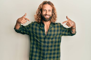 Sakallı, uzun saçlı, sıradan kıyafetler giyen, kendine güvenen, gülümseyen, kendini gururlu ve mutlu gösteren yakışıklı bir adam.. 