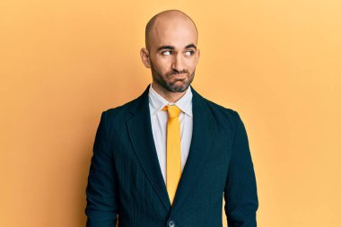 Genç İspanyol takım elbiseli ve kravatlı adam gülümseyip yan tarafa bakıyor ve düşünüyor.. 