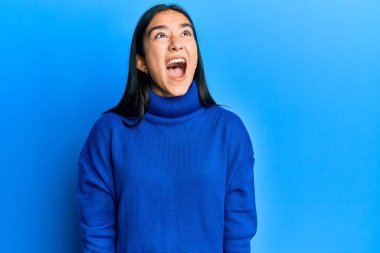 Asyalı genç bir kadın, sıradan bir kazak giyiyor kızgın ve kızgın bağırıyor sinirli ve öfkeli, öfkeyle bağırıyor. öfke ve agresif konsept. 