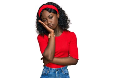 Güzel Afrikalı genç bir kadın gündelik kıyafetler giyip kollarını kavuşturarak depresyondan sıkılmış ve yorgun görünüyor.. 