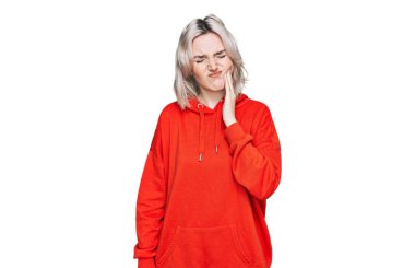 Sıradan kıyafetler giyen genç sarışın kız diş ağrısı ya da diş hastalığından dolayı acı dolu bir ifadeyle ağıza dokunuyor. dişçi 