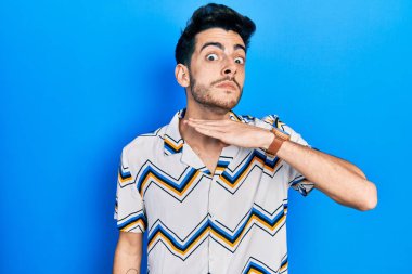 Gündelik kıyafetler giyen, boğazını bıçak niyetine kesen, saldırganlığı şiddetle tehdit eden genç İspanyol bir adam. 