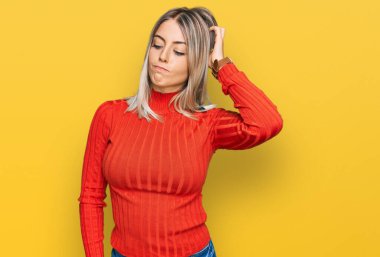 Gündelik kıyafetler giyen güzel sarışın kadın kafasını karıştırıyor ve soruyu merak ediyor. Şüpheyle kararsız, kafa kafaya düşünerek. Düşünceli kavram. 