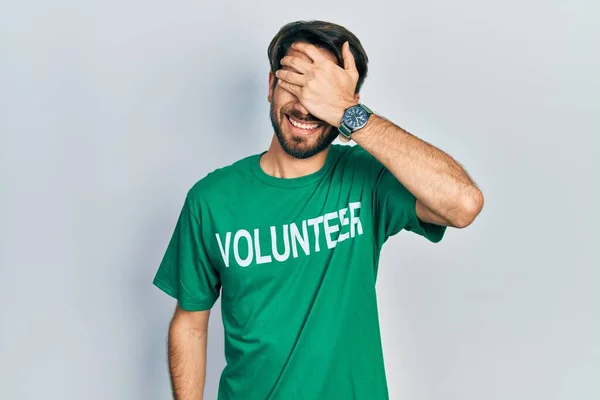 Jovem Hispânico Vestindo Camiseta Voluntária Sorrindo Rindo Com Mão Rosto — Fotografia de Stock