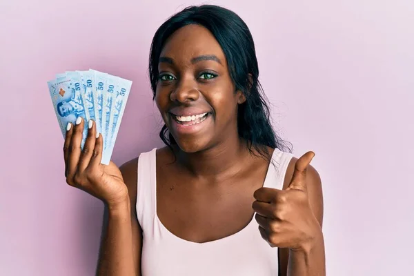 Joven Mujer Afroamericana Sosteniendo Billetes Tailandeses Baht Sonriendo Feliz Positivo — Foto de Stock