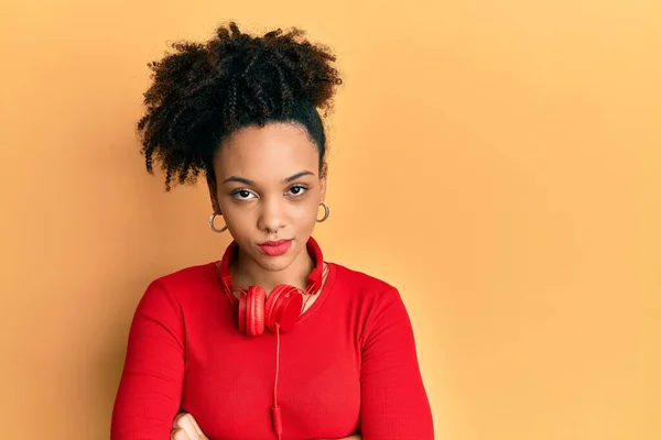 Chica Afroamericana Joven Escuchando Música Usando Auriculares Escépticos Nerviosos Desaprobando —  Fotos de Stock