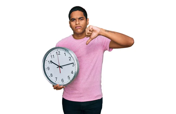 Young Handsome Hispanic Man Holding Big Clock Angry Face Negative — Stock Photo, Image