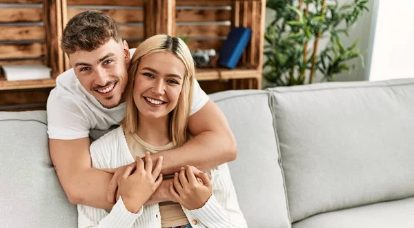 Young Caucasian Couple Smiling Happy Hugging Sitting Sofa Home — Stock Photo, Image