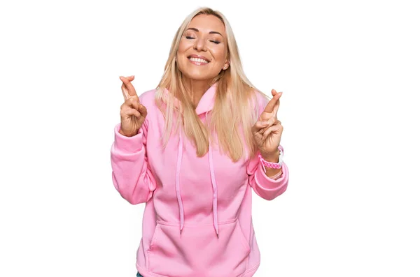 Ung Blond Kvinna Bär Casual Sweatshirt Gestikulerande Finger Korsade Leende — Stockfoto