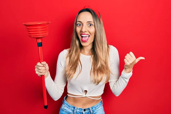 Hermosa Mujer Hispana Sosteniendo Émbolo Del Inodoro Apuntando Con Pulgar — Foto de Stock