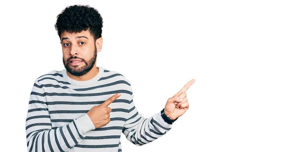 Young Arab Man Beard Wearing Casual Striped Sweater Pointing Aside — Stock Photo, Image