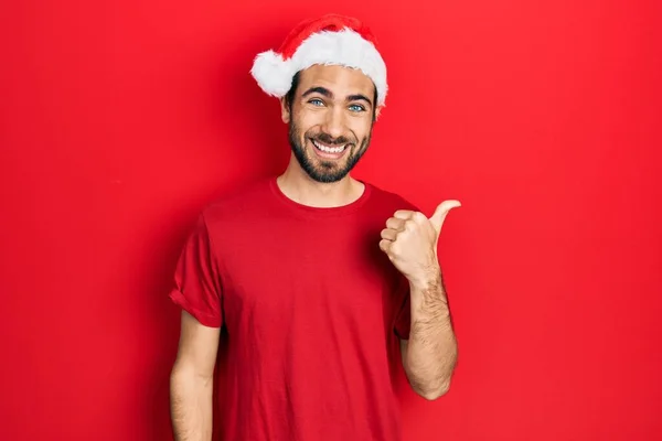 Νεαρός Ισπανός Φοράει Χριστουγεννιάτικο Καπέλο Χαμογελώντας Χαρούμενο Πρόσωπο Και Δείχνοντας — Φωτογραφία Αρχείου