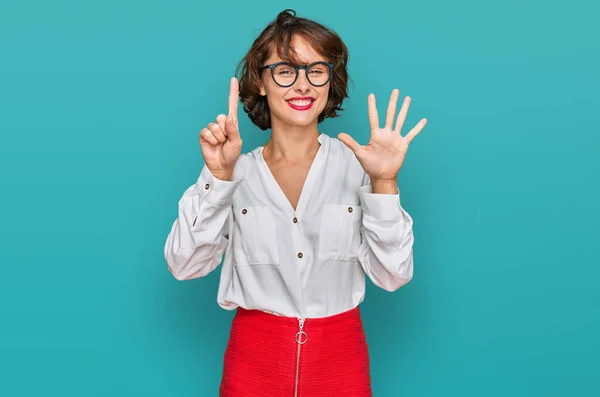 自信と幸せ笑顔ながら ビジネススタイルとメガネを身に着けている若いヒスパニック系の女性が表示され 指の数で指摘6 — ストック写真