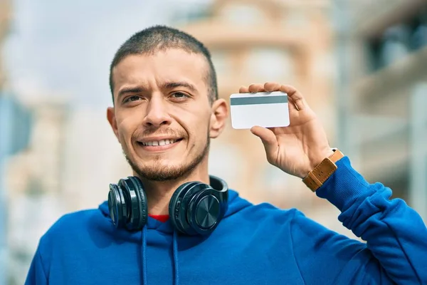 Joven Hispano Usando Auriculares Con Tarjeta Crédito Ciudad —  Fotos de Stock