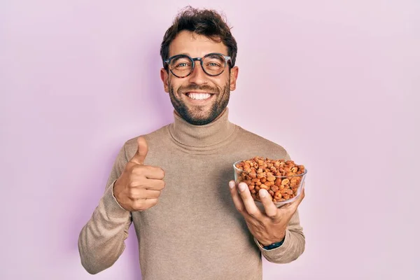 Homem Bonito Com Barba Segurando Amendoins Sorrindo Feliz Positivo Polegar — Fotografia de Stock