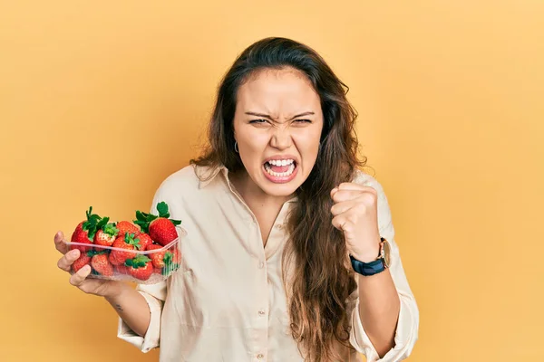 Ung Latinamerikansk Flicka Håller Jordgubbar Arga Och Galna Höja Näve — Stockfoto