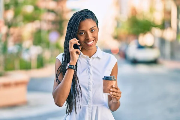 若いアフリカ系アメリカ人の女性がスマートフォンで話して街でコーヒーを飲んで — ストック写真