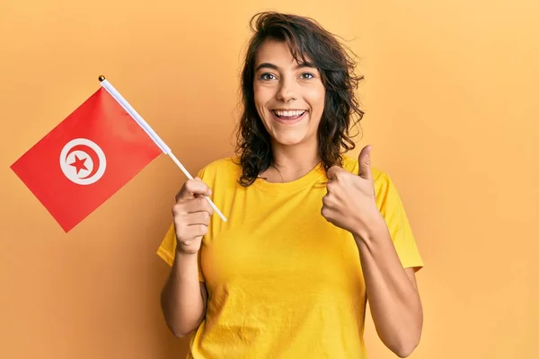 Young Hispanic Woman Holding Tunisia Flag Smiling Happy Positive Thumb — Stock Photo, Image