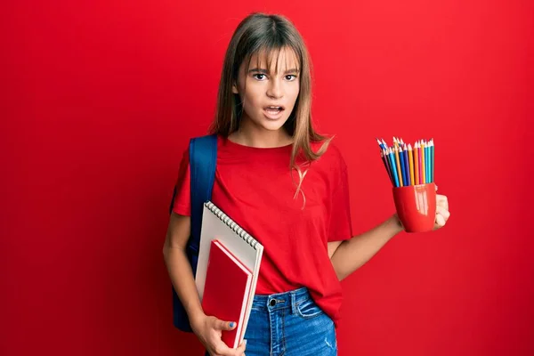 ティーンCaucasian女の子保持アートノートと色鉛筆でショック顔 見て懐疑的と皮肉 驚きでオープン口 — ストック写真
