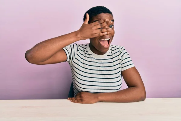 Jovem Afro Americana Vestindo Roupas Casuais Sentada Mesa Espreitando Choque — Fotografia de Stock