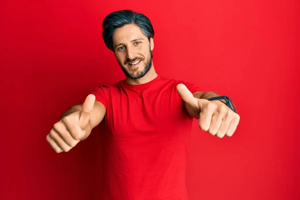 Jovem Hispânico Vestindo Camisa Vermelha Casual Aprovando Fazer Gesto Positivo — Fotografia de Stock