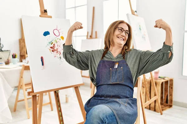 Sanat Stüdyosundaki Orta Yaşlı Kadın Gururla Gülümseyen Kol Kaslarını Gösteriyor — Stok fotoğraf
