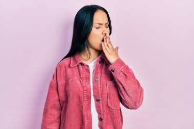 Burun piercingli, sıradan pembe ceket giyen güzel İspanyol kadın ağzıyla ağzını kapatmaktan sıkılmış. Huzursuz ve uykulu.. 