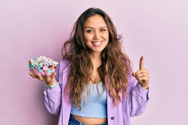 Genç İspanyol kız elinde şeker kasesiyle gülümsüyor bir fikirle ya da soru işareti yaparak mutlu bir yüzle, bir numara 