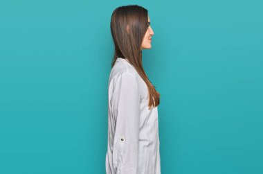 Genç ve güzel bir kadın günlük giysiler içinde, rahat bir görünüm takınıyor doğal bir yüz ve kendine güvenen bir gülümsemeyle poz veriyor.. 