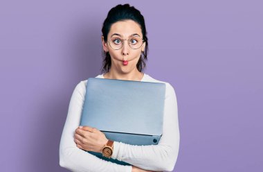 Bilgisayar laptopu kullanan genç İspanyol kadın balık suratlı ve şaşı gözlü, çılgın ve komik.. 