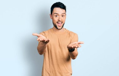 Sakallı, sıradan tişörtlü, neşeli gülümseyen, yardım eli uzatan ve kabul gören İspanyol bir adam.. 