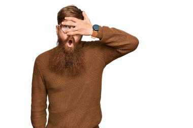 Genç İrlandalı kızıl elbiseli ve gözlüklü adam şok içinde yüzünü ve gözlerini kapayarak utangaç ifadesiyle parmaklarının arasından bakıyor.. 